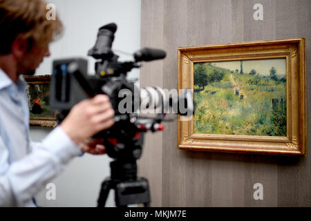 08.05.2018, Berlin : un caméraman filme le tableau "La hausse du chemin à travers les hautes herbes" par l'artiste Pierre-Auguste Renoir dans l'exposition "Wanderlust. De Caspar David Friedrich à Auguste Renoir "dans l'Alte Nationalgalerie. À partir de 10.05. jusqu'à 16.09.2018, des prêts et des œuvres du musée, les collections seront affichées. Photo : Britta Pedersen/dpa | conditions dans le monde entier Banque D'Images