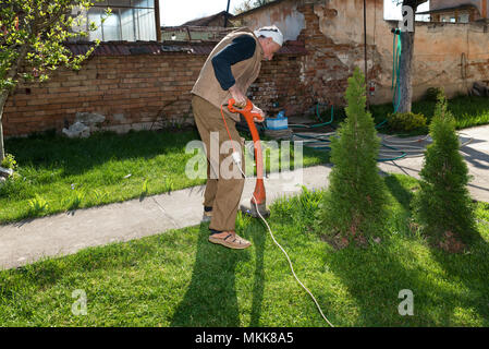 Man aide jardinage débroussailleuse Banque D'Images