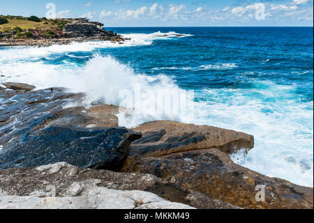 La vue imprenable sur le célèbre Coogee Beach à pied près de Bondi Beach, New South Wales, Australie. Vagues se brisant sur les rochers avec une belle bl Banque D'Images