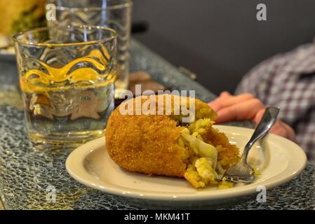 Une spécialité de la région de Sicile, Italie : l'arancino. L'alimentation de rue basée sur le riz, assaisonnée de beaucoup de manières, sauce à la viande, la mozzarella, les épinards, les pois. Banque D'Images