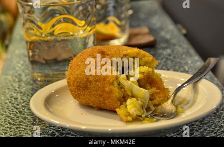 Une spécialité de la région de Sicile, Italie : l'arancino. L'alimentation de rue basée sur le riz, assaisonnée de beaucoup de manières, sauce à la viande, la mozzarella, les épinards, les pois. Banque D'Images