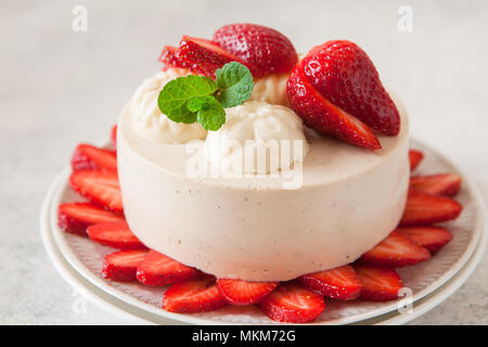 Cheesecake léger avec remplissage de fraises décorées avec des baies fraîches et de menthe. L'été bio saine tarte dessert. Banque D'Images