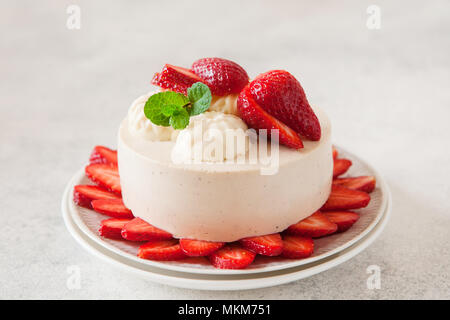 Cheesecake léger avec remplissage de fraises décorées avec des baies fraîches et de menthe. L'été bio saine tarte dessert. Banque D'Images