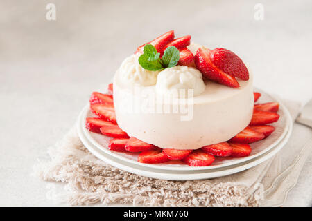 Cheesecake léger avec remplissage de fraises décorées avec des baies fraîches et de menthe. L'été bio saine tarte dessert. Banque D'Images