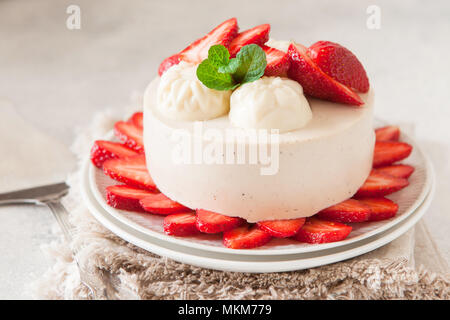 Cheesecake léger avec remplissage de fraises décorées avec des baies fraîches et de menthe. L'été bio saine tarte dessert. Banque D'Images