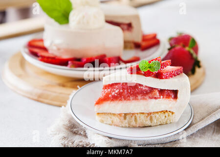 Tranche de gâteau au fromage avec garniture aux fraises décorées avec des baies fraîches et de menthe. L'été bio saine tarte dessert. Banque D'Images