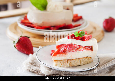 Tranche de gâteau au fromage avec garniture aux fraises décorées avec des baies fraîches et de menthe. L'été bio saine tarte dessert. Banque D'Images