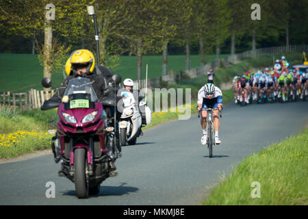 Strong & puissant, seul cycliste ensoleillées, de grand groupe de cyclistes masculins en peloton - Tour de Yorkshire en 2018, près de Bradford, Angleterre, Royaume-Uni. Banque D'Images