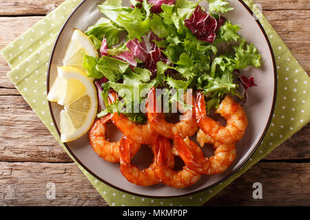 Crevettes glacées au miel délicieux et la sauce de soja et salade fraîche close-up sur une plaque sur une table horizontale. haut Vue de dessus Banque D'Images