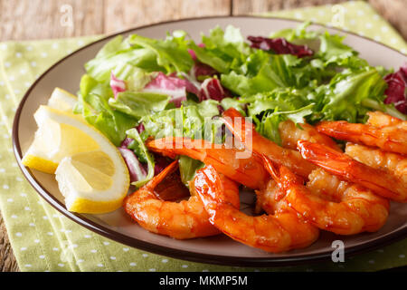 Crevettes glacées au miel délicieux et la sauce de soja et salade fraîche close-up sur une plaque sur une table horizontale. Banque D'Images