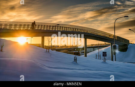 Personne sur un vélo sur une passerelle traversant l'hiver, Reykjavik, Islande Banque D'Images