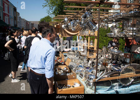 L'argenterie sur blocage du marché de Portobello Road à Notting Hill, à l'ouest de Londres, Angleterre, Royaume-Uni. Les personnes bénéficiant d'une journée ensoleillée à traîner dans le célèbre marché de dimanche, lorsque la ligne des stands d'antiquités de la rue. Portobello Market est le plus grand marché d'antiquités avec plus de 1 000 distributeurs de vendre tout type de meubles anciens et de collection. Visiteurs viennent du monde entier pour marcher le long d'une des rues de Londres Best Loved. Banque D'Images