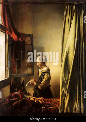 Jeune fille lisant une lettre à une fenêtre ouverte Banque D'Images