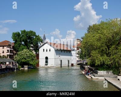 Les gens assis à l'ombre et de détente le long de la rivière Thiou au milieu de la vieille ville, Annecy, France Banque D'Images
