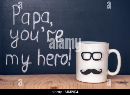 Tasse avec moustache, lunettes et texte manuscrit Papa vous êtes mon héros sur tableau, célébration concept de la Fête des Pères Banque D'Images