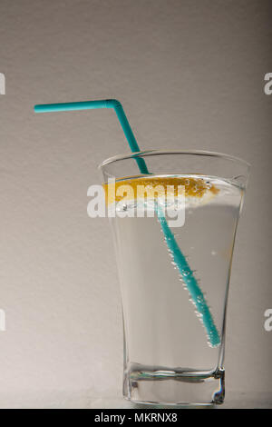 Un verre de l'eau fraîche et un tilleul. Eau minérale . Fond gris de l'eau minérale Banque D'Images