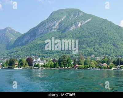 Vue sur le paysage de montagne au-delà des rives du lac d'Annecy à Menton-Saint-Bernard, France. Banque D'Images
