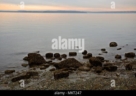 WA15351-00...WASHINGTON - le coucher du soleil sur un jour nuageux le long de la Puget Sound à Alki Point à West Seattle. Banque D'Images