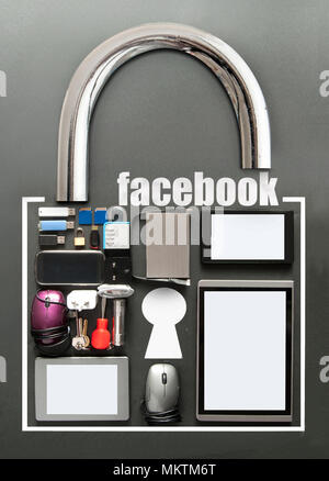 Facebook, avec divers appareils, y compris les comprimés, souris d'ordinateur, les cartes USB en forme de cadenas sur le tableau arrière-plan Banque D'Images