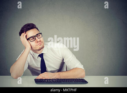 Handsome Young man leaning on part et s'endormir dans l'ennui pendant le travail. Banque D'Images