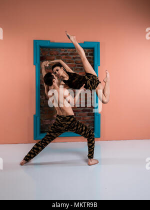 Danseuse de ballet moderne de protection en couple couleur militaire sport pantalons et chemise performing art jump élément avec arrière-plan Banque D'Images