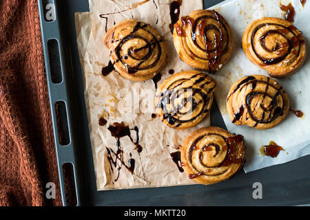 À la cannelle fraîchement cuit au four avec sauce au chocolat et caramel. Prêt à manger. Banque D'Images