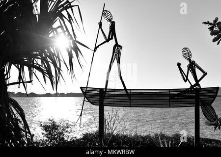 Sculpture en acier d'autochtones pagayer dans un canoë avec sunsetArtwork à Jezzine barracks, Kissing point fort, Townsville, Queensland, Australie Banque D'Images