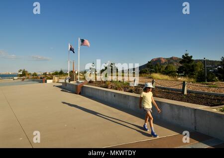 Jeune fille passe devant les drapeaux américains et australiens à la caserne de Jezzine Jezzine, casernes, Kissing point fort, Townsville, Queensland, Australie Banque D'Images