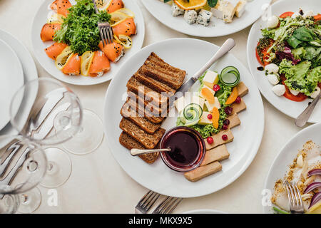 Les plats servis à la table pour les vacances. Des couverts et de l'alimentation sur les nappes blanches dans le restaurant. La conception d'un banquet de fête. L'alimentation de luxe pour les clients et les visiteurs. Banque D'Images