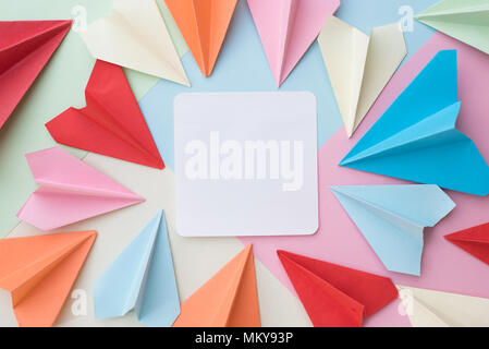 Avion de Papier de couleur blanche et Memo Pad papier coloré sur fond pastel. memo,,organiser et air mail concept Banque D'Images