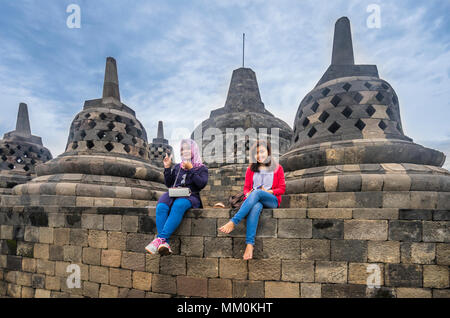 Les visiteurs apprécient la vue sur la plaine de Kedu du haut d'une terrasse circulaire de 9e siècle Borobudur temple bouddhiste, le centre de Java, Indonésie Banque D'Images