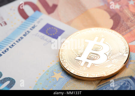 Les bitcoins or empilées sur les billets en euros contexte Banque D'Images