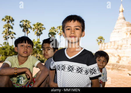 Bagan, Myanmar, 29 Décembre 2017 : trois garçons et une fille fièrement posent devant une pagode à Bagan, Myanmar Banque D'Images
