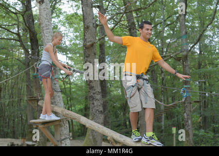 Jeune homme et femme s'amuser dans les arbres Banque D'Images