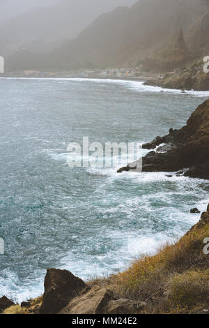 Les vagues de l'océan avec pulvérisation de soufflage roulant sur la côte volcanique rocheux. Paul Pombas place près de Ribeira Grande Village. Santo Antao. Cap Vert Banque D'Images