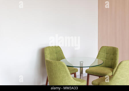 Close up fauteuil vert style moderne en béton blanc sur fond d'angle Banque D'Images