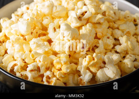 Popcorn savoureux avec du fromage cheddar et le parmesan dans un bol macro sur la table horizontale. Banque D'Images