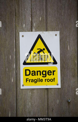 Un signe d'avertissement un toit fragile sur une grange avec un toit ondulé. North West Lancashire England UK Banque D'Images