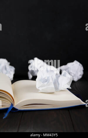 Notes blanc sur une table en bois. Concept d'écriture - le papier froissé wads avec le bloc-notes Banque D'Images