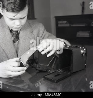 Années 1950, historiques, jeune écolier mettre 127 roll film dans un appareil-photo de film Kodak Brownie. Simple et économique, c'est l'un des plus importants des caméras dans l'histoire comme il a introduit le concept de la 'instantané' pour le marché de masse et est particulièrement populaire avec les enfants Banque D'Images