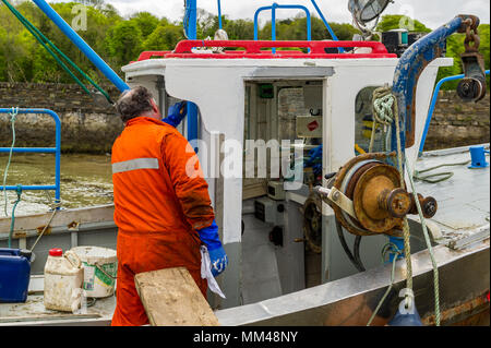 Pêcheur peint son voile qui est liée à une rampe à Bantry, dans le comté de Cork, Irlande. Banque D'Images