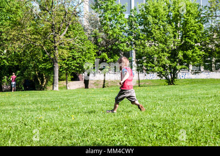 Prague, République tchèque, 28 avril 2018 petit garçon dans truc et short running in park sur l'herbe des arbres en arrière-plan Banque D'Images