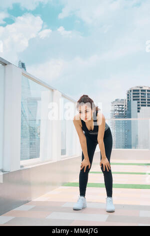 Fatigué asian woman runner prendre du repos après l'exécution Banque D'Images