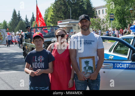 KURSK REGION Krasnoyarsk, Russie, - le 9 mai 2018. Duringin famille prend des photos de la parade du Régiment immortel avec des portraits de leurs proches wh Banque D'Images