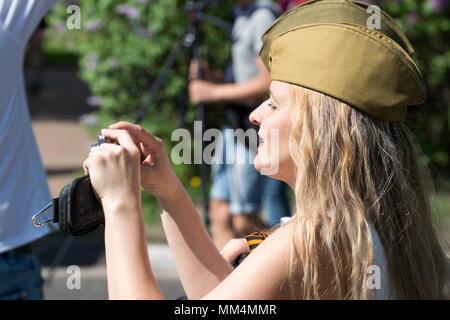 KURSK REGION Krasnoyarsk, Russie, - le 9 mai 2018. Une fille blonde dans un bouchon vert militaire tire une parade de l'Immortel Regiment avec portraits des Banque D'Images