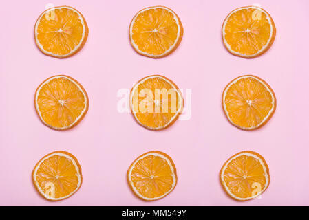 Morceaux d'orange. Cercles avec orange. Fond rose. Les agrumes. Fruits sur un fond rose. Lavande Rose. Banque D'Images