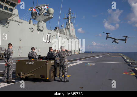 Une MV-22B Osprey avion à rotors basculants décolle depuis la cabine de pilotage de la Royal Australian Navy's HMAS Adelaide (L01), 7 septembre 2017, marquant la première fois qu'un balbuzard a atterri sur le bateau. L'Osprey appartient à l'escadron 265 à rotors basculants moyen maritime (renforcée), qui fait partie de la 31e unité expéditionnaire de marines de l'aviation de l'élément de combat. L'Osprey est capable de décoller comme un hélicoptère et de voler comme un aéronef à voilure fixe, lui permettant de voyager plus rapidement et sur de plus grandes distances que ses prédécesseurs. La 31e MEU, qui a récemment participé à l'exercice Talisman Saber alongsid Banque D'Images