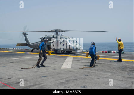 170908-N-GC965-034 U.S. 5ÈME ZONE DES OPÉRATIONS DE LA FLOTTE (sept. 8, 2017) Les marins affectés au ministère de l'air à bord du navire d'assaut amphibie USS America (LHA 6) Retirer les chaînes et cale d'un MH-60S Sea Hawk affecté à l 'Wildcards' de la mer d'hélicoptères de l'Escadron de Combat (HSC) 23 avant que l'avion décolle pour une visite, un conseil, une perquisition et saisie de la mission de formation dans le cadre de l'exercice 2017 Dague Alligator. Dague d'Alligator est un combat unilatéral, dirigé par répétition de la Naval Amphibious Task Force Force, 51/5ème Marine Expeditionary Brigade, en combinant de la Marine et du C Banque D'Images