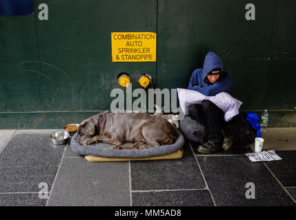 Un sdf et son chien reste durant la journée à Manhattan, New York City le 6 mai 2018. Banque D'Images