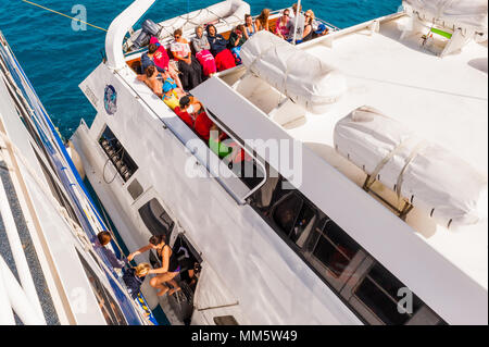 Passagers et produits sont transférés d'un bateau de plongée à un autre milieu de l'océan au-dessus de la Grande Barrière de Corail, Queensland, Australie. Banque D'Images